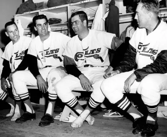 Houston Astros Jerseys 6 Houston Colt .45s players sitting in the dugout wearing white uniforms with ‘Colts’ script and pistol logo, representing the team’s original 1962–1964 era