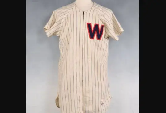 Washington Senators home jersey from 1901–1960 featuring cream fabric with navy pinstripes and a large red ‘W’ outlined in navy on the chest, representing the team’s classic navy-and-red look during the Walter Johnson era