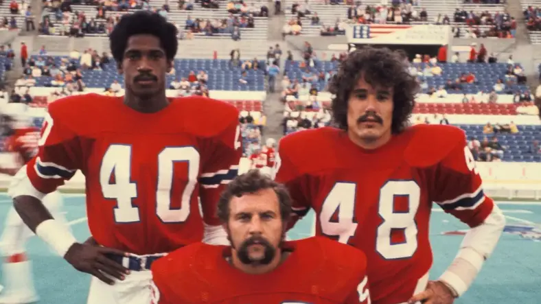 New England Patriots players wearing red jerseys from the Pat Patriot era, 1960–1992