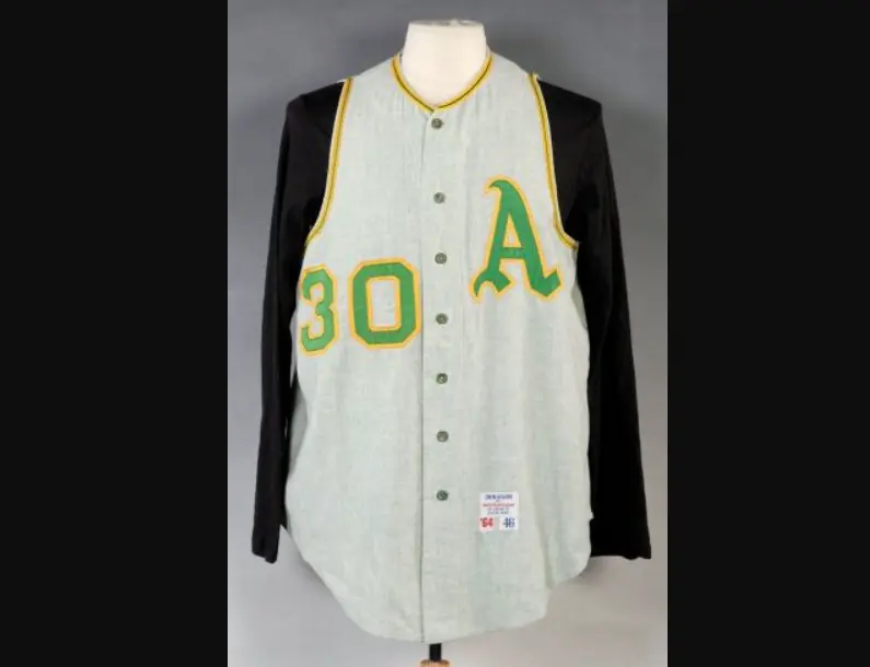 Kansas City Athletics jersey from 1955–1967 featuring a large green ‘A’ and number 30 with gold trim, representing Charlie Finley’s bold green and gold color era