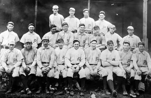 1887–1947 Pittsburgh Pirates team photo showing players in early flannel uniforms with block ‘P’ logos on their chests, representing the blue and red era of the Alleghenys and early Pirates