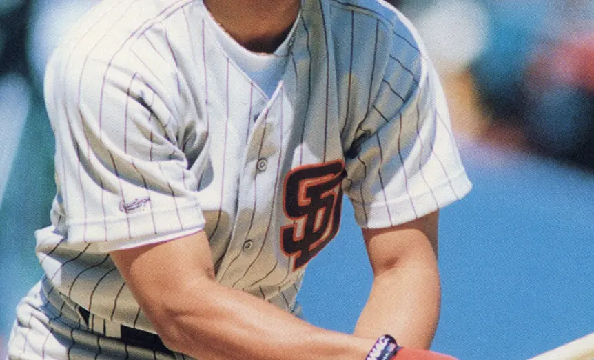 1980s San Diego Padres white jersey with thin brown pinstripes and interlocking ‘SD’ logo in brown and orange, representing the refined brown pinstripe era.
