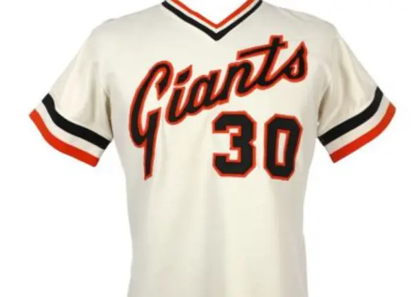1970s San Francisco Giants pullover jersey in cream with bold orange and black script ‘Giants’ and number 30, featuring striped V-neck and sleeve trim