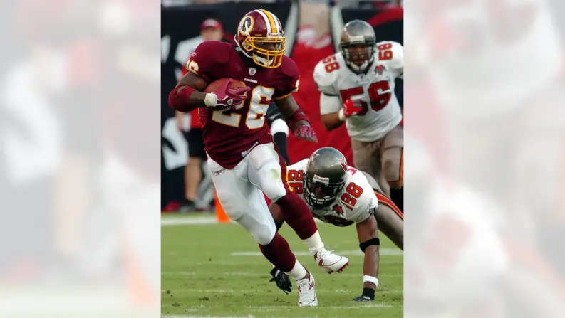 Action photo of a Washington Football Team player from the 2020–2021 season wearing a burgundy jersey with white pants and a plain burgundy helmet displaying only the player’s number, representing the team’s brief logo-free rebrand era